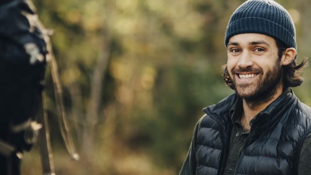 Smilende mann i skogen